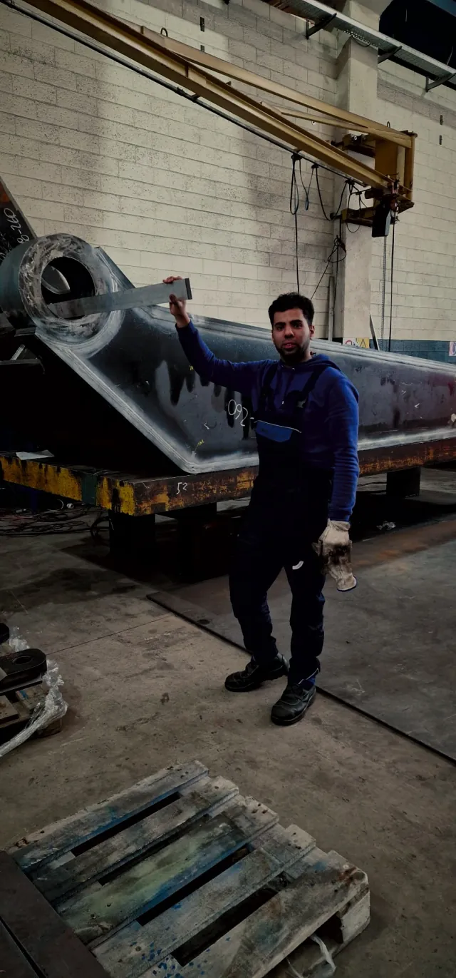 Il titolare accanto a una grande struttura saldata in officina